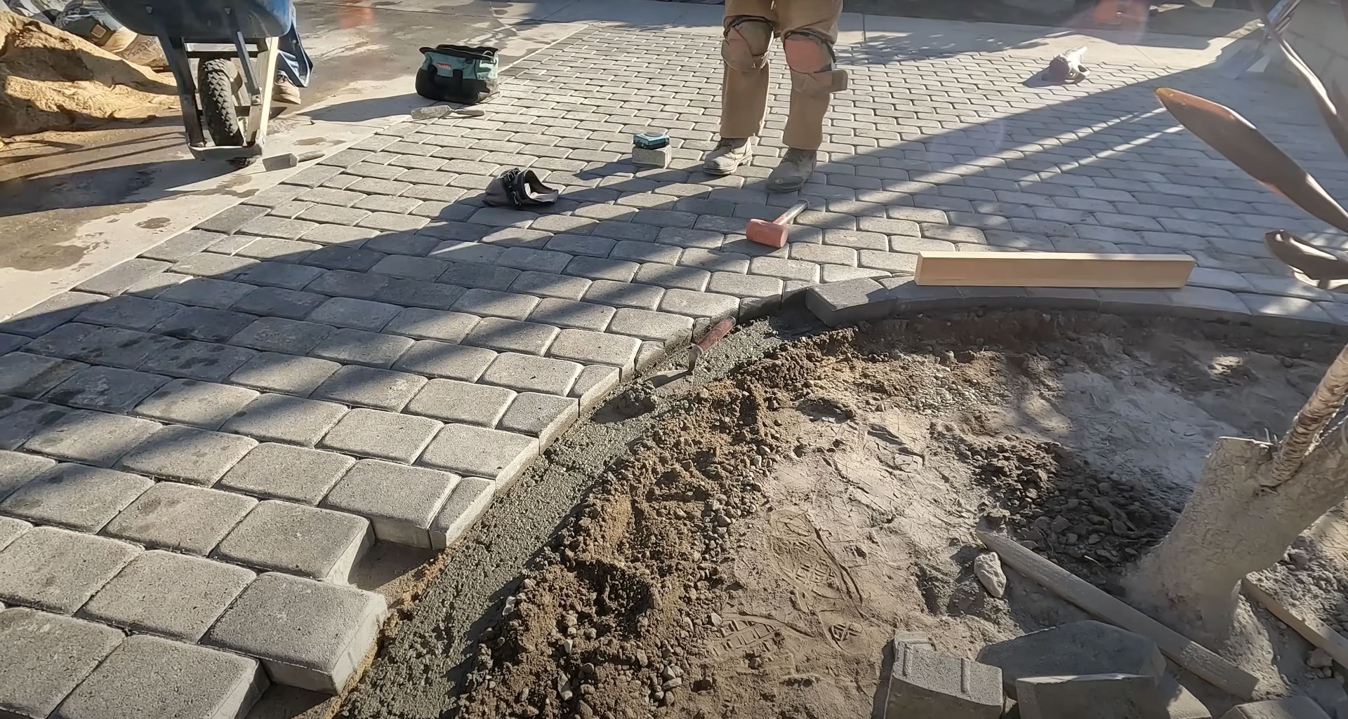 Workers installing concrete pavers with precision