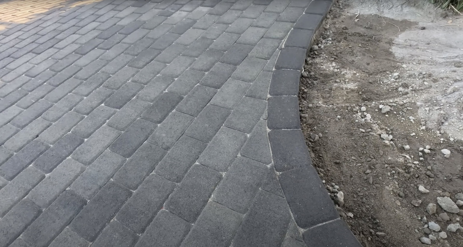 Concrete paver installation showing precision herringbone pattern layout